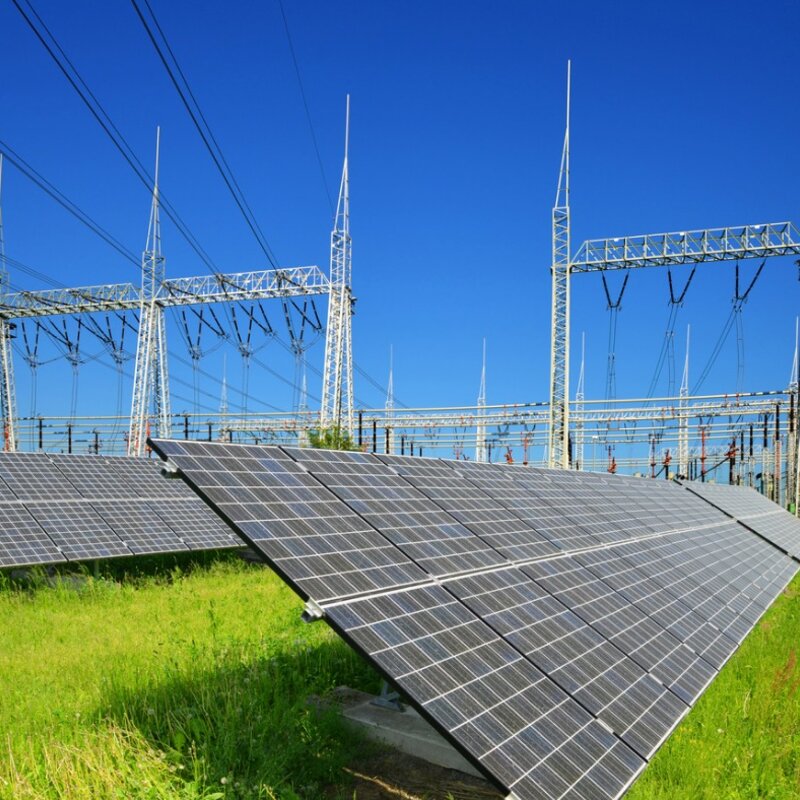 Solar energy panels in the background high voltage power substation