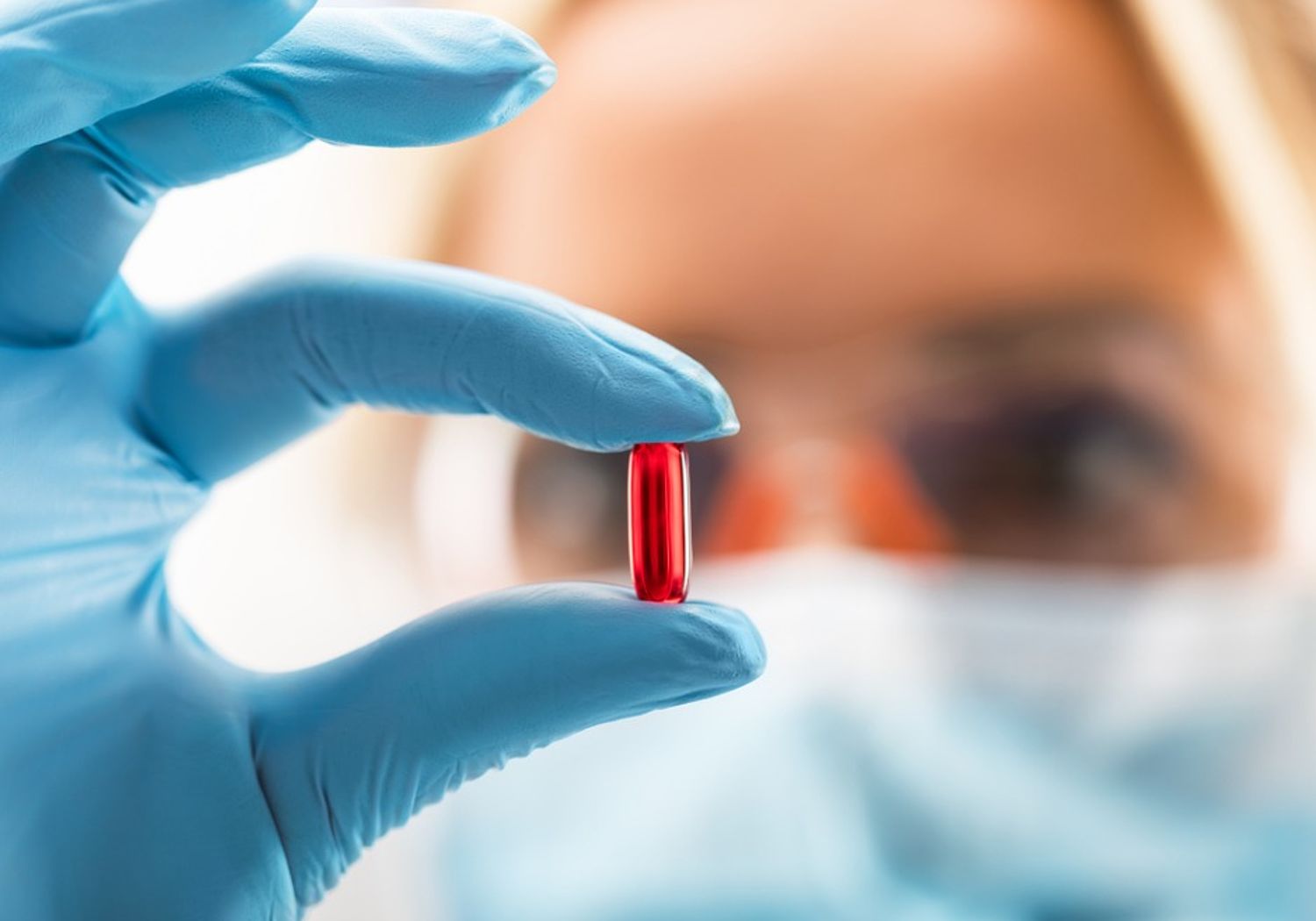 Image showing a scientist holding a red transparent pill