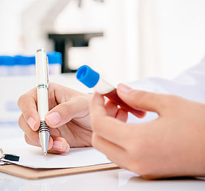 Image of a scientist recording blood anaysis results in laboratory