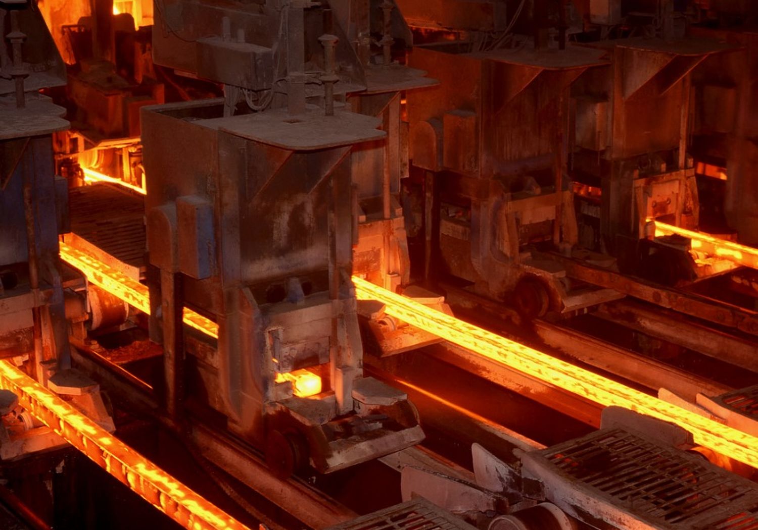 Image showing red-hot metal bars being made at an industrial plant