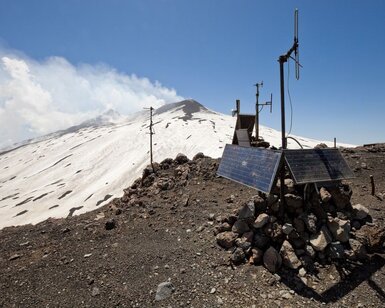 On the side of a smoking volcano a seismograph powered by solar cells is transmitting vibration data to headquarters