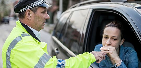 A driver taking a breath test at the roadside