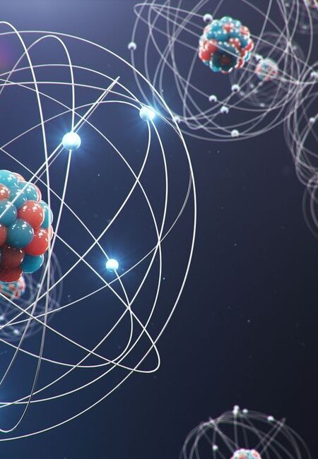 Against a dark background are an artist’s illustration of atomic structures with an atom with a large number of neutrons and protons in the foreground with other atoms in the distance