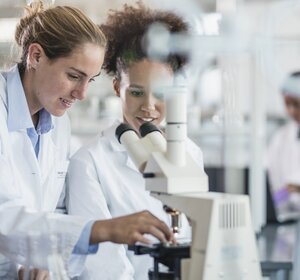 Image showing two scientists examiining a sample with a microscope